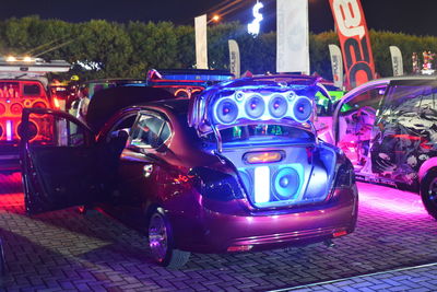 Cars on illuminated street in city at night