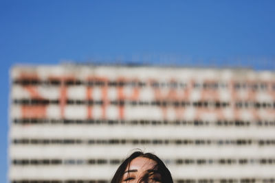 High section of woman against building in city