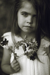 Portrait of cute girl holding flower