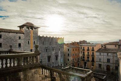 Buildings in city against cloudy sky