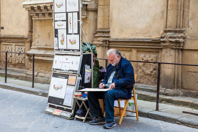 Full length of man sitting on chair