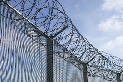 Low angle view of barbed wire against sky