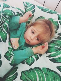 High angle view of cute girl lying on bed at home