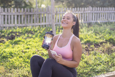 Young happy athlete woman in green park after sport practice