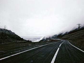 Road by mountain against sky