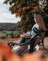Side view of young woman sitting outdoors