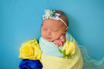 High angle view of cute baby girl with stuffed toy against blue background