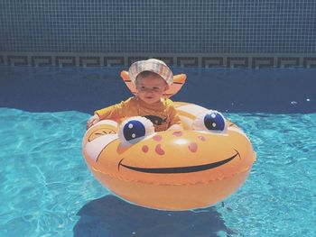 Baby boy on inflatable ring in swimming pool