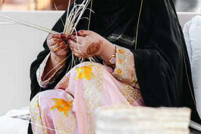 Midsection of bride holding bouquet