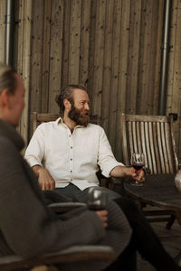 Friends sitting on porch and drinking wine