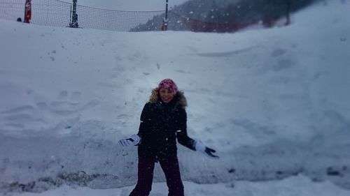 Woman standing on snow covered field