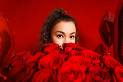 Portrait of woman holding red flowers