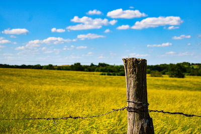 Wooden fence on field against sky