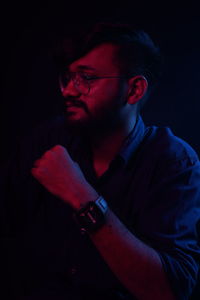 Thoughtful young man in darkroom