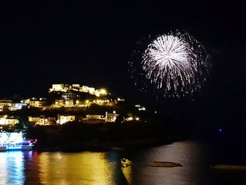 Firework display over river at night