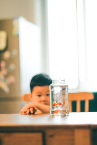 Portrait of boy drinking glass on table