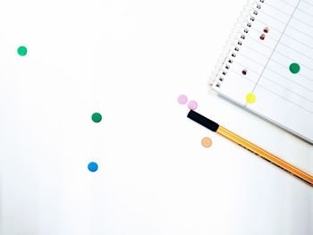 High angle view of colored pencils against white background