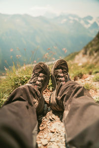 Low section of men relaxing on mountain