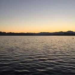 Scenic view of lake against clear sky during sunset