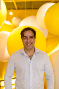 Portrait of smiling man standing at balloons