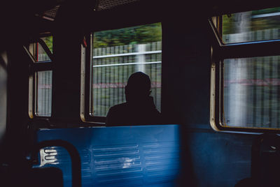 Silhouette of man sitting in train