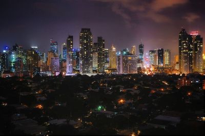 Illuminated cityscape against sky at night