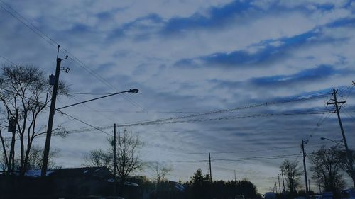 Low angle view of power lines against sky