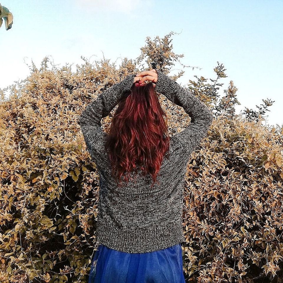 plant, tree, real people, lifestyles, sky, one person, leisure activity, nature, hair, hairstyle, three quarter length, day, standing, casual clothing, women, rear view, growth, beauty in nature, long hair, outdoors, human arm, warm clothing, arms raised