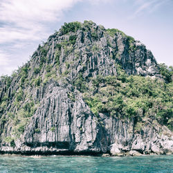 Rock formations by sea against sky