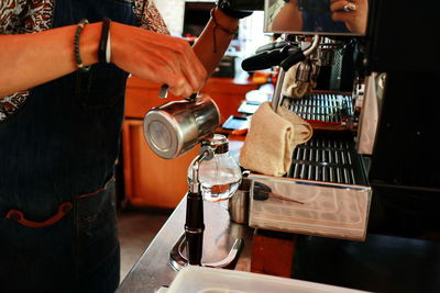 Midsection of man working with coffee in cafe