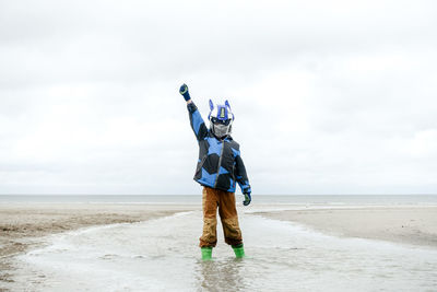 Full length of disguised boy on beach