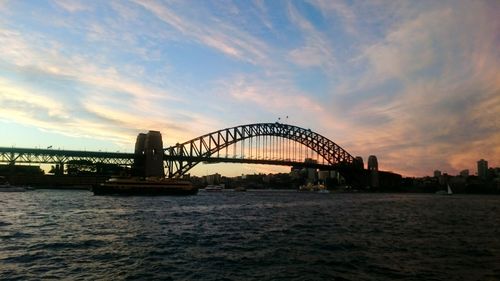 Bridge over river against cloudy sky