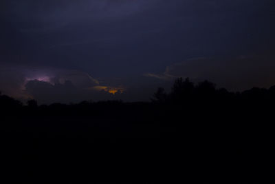 Silhouette of trees against sky at night