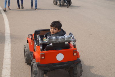 High angle view of boy driving toy car on street