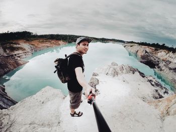 Full length portrait of young man standing on mountain