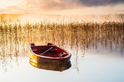 Boat in lake during sunset