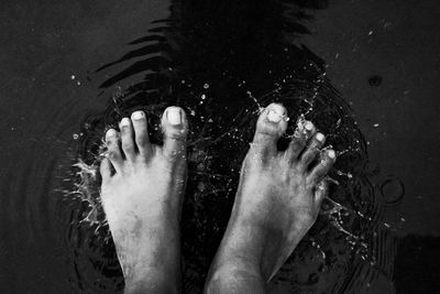 Low section of man relaxing in swimming pool