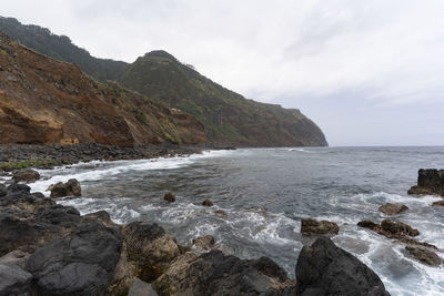 Scenic view of sea and mountains against sky