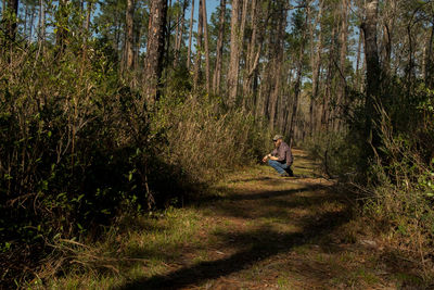 Man sitting on grass in forest