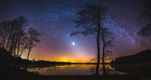 Scenic view of lake against sky at night