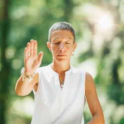 Qi gong female expert doing qigong exercises outdoor for moving chi or energy in the body