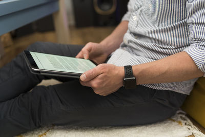 Businessman using digital tablet while sitting at home