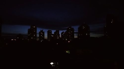 Illuminated cityscape against sky at night