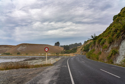 Road leading towards mountain against sky