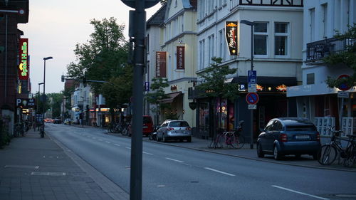 Cars on road by buildings in city