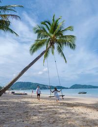 People on beach against sky