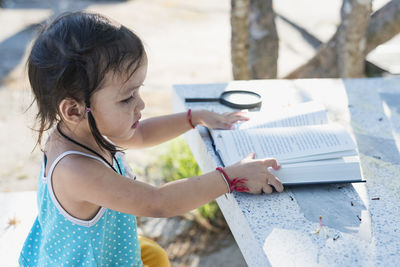 Side view of girl drawing on book