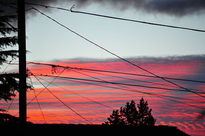 Silhouette of power lines against cloudy sky