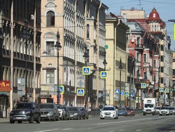 Traffic on road by buildings in city