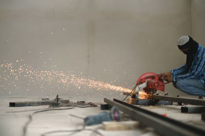 Welder welding metal in workshop